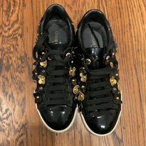 Black patent leather sneakers with black and gold flowers.